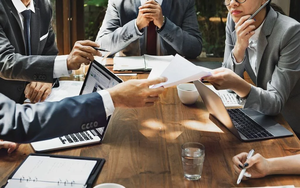 asian discussing on a table with paper documents